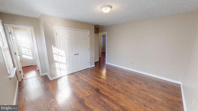 12459 Charter Oak Ct, Waldorf, MD 20601 - unfurnished bedroom featuring a textured ceiling, dark hardwood / wood-style flooring, and a closet