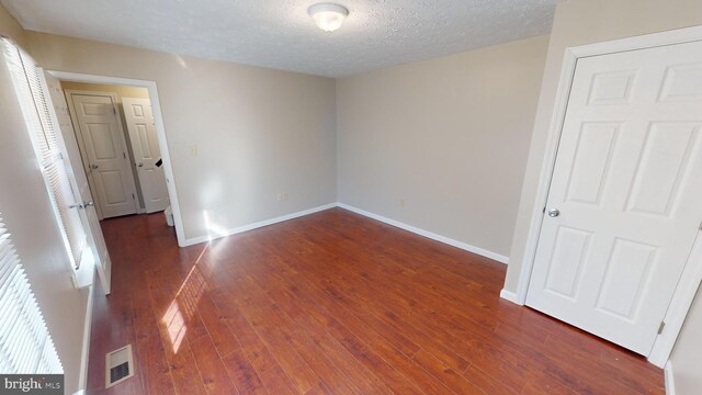 12459 Charter Oak Ct, Waldorf, MD 20601 - unfurnished bedroom featuring dark wood-type flooring and a textured ceiling
