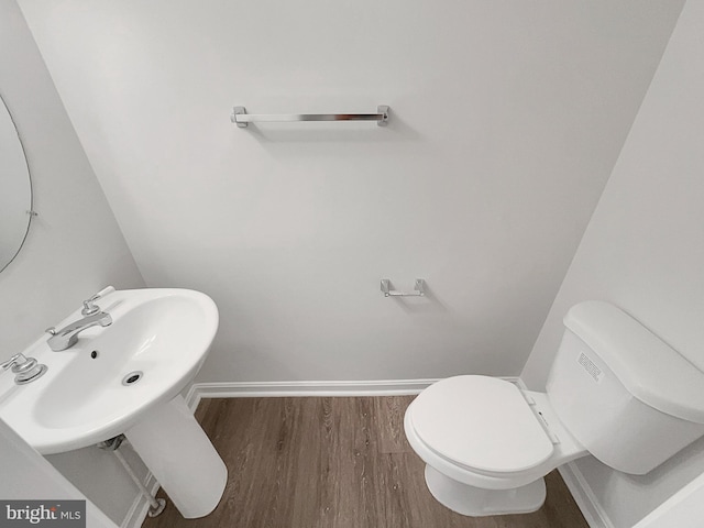 bathroom with hardwood / wood-style floors and toilet