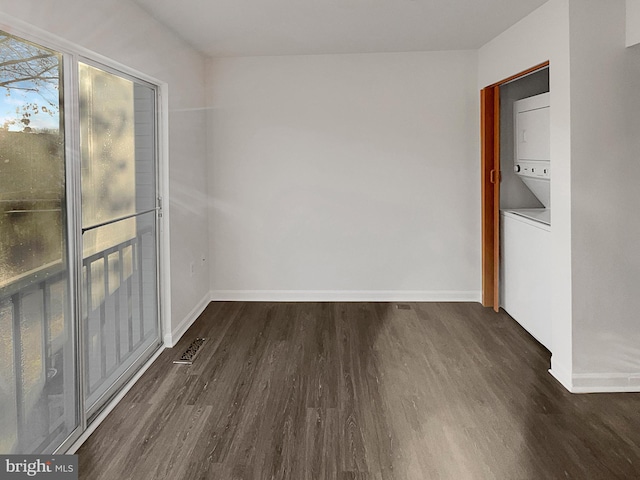 interior space with dark hardwood / wood-style floors and stacked washing maching and dryer