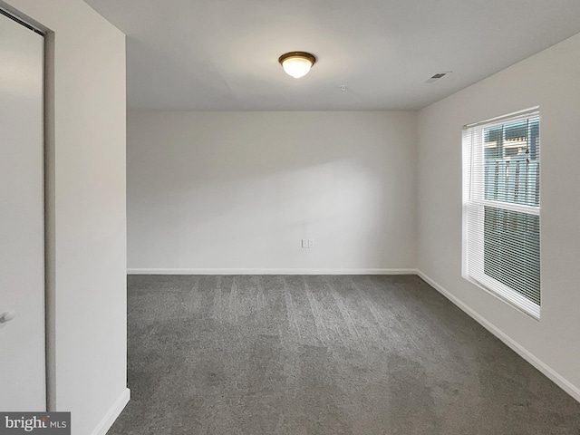 empty room featuring dark colored carpet