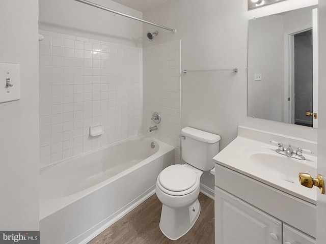 full bathroom featuring vanity, tiled shower / bath combo, wood-type flooring, and toilet