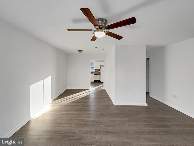 empty room featuring dark wood-type flooring and ceiling fan