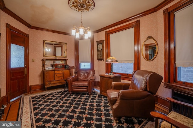 sitting room with ornamental molding, a wealth of natural light, and a notable chandelier