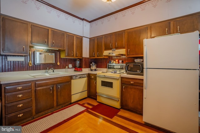 kitchen with crown molding, white appliances, sink, and light wood-type flooring