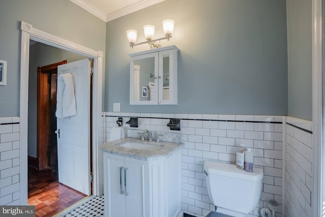 bathroom with toilet, crown molding, tile walls, parquet floors, and vanity