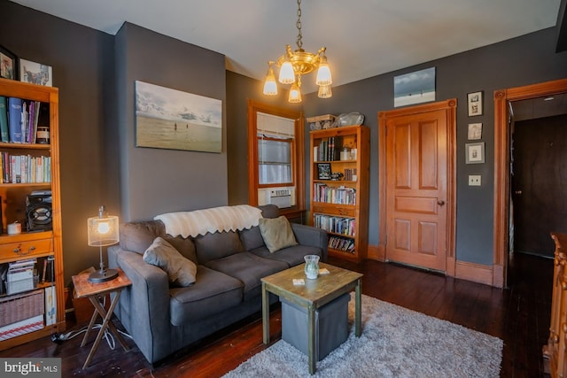 living room with dark wood-type flooring, cooling unit, and an inviting chandelier