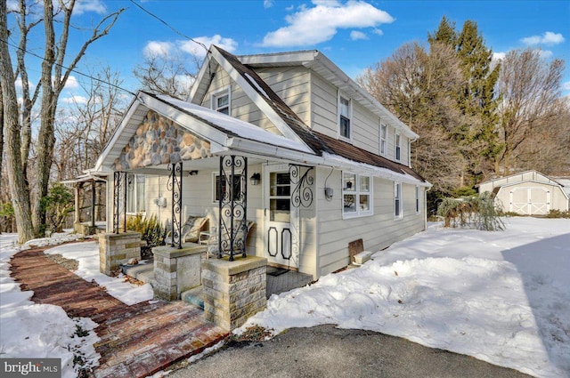 view of front of home with a porch and a storage unit