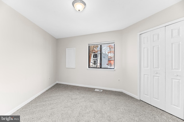 unfurnished bedroom featuring carpet flooring and a closet