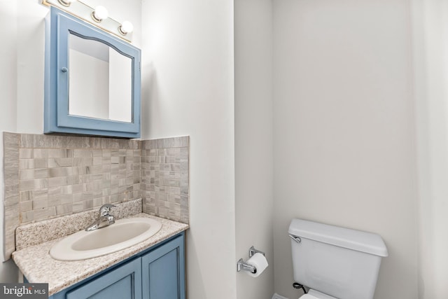 bathroom featuring tasteful backsplash, vanity, and toilet