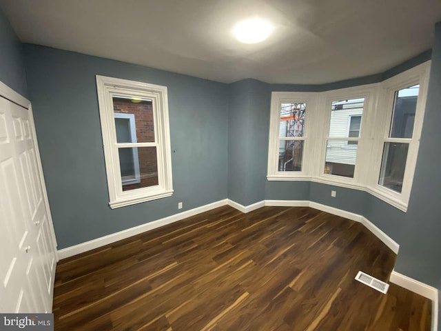 spare room with dark wood-type flooring