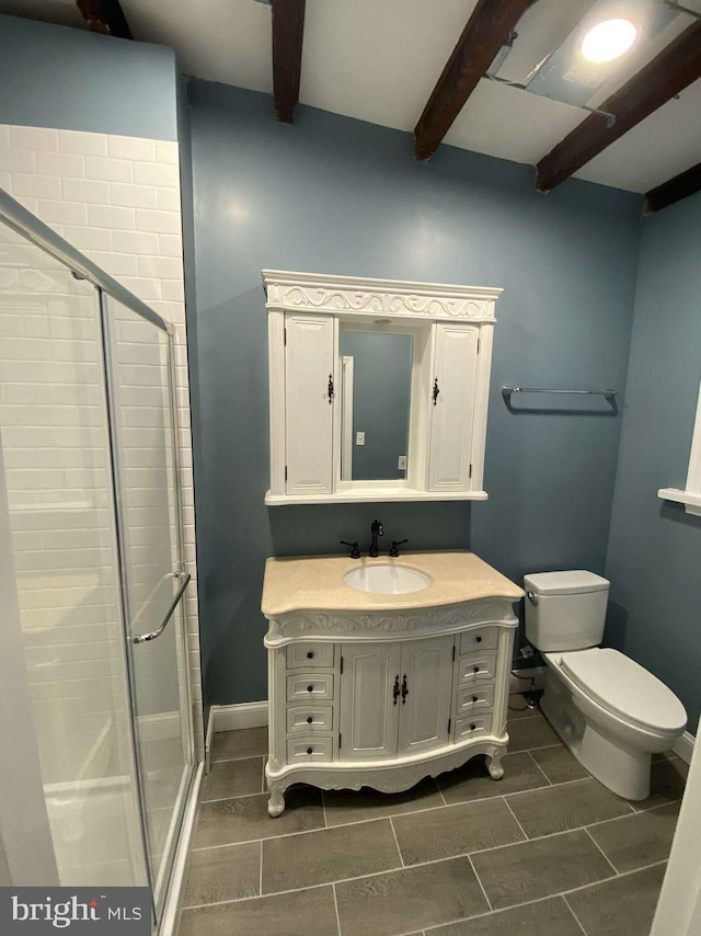 bathroom with beamed ceiling, vanity, toilet, and a shower with shower door