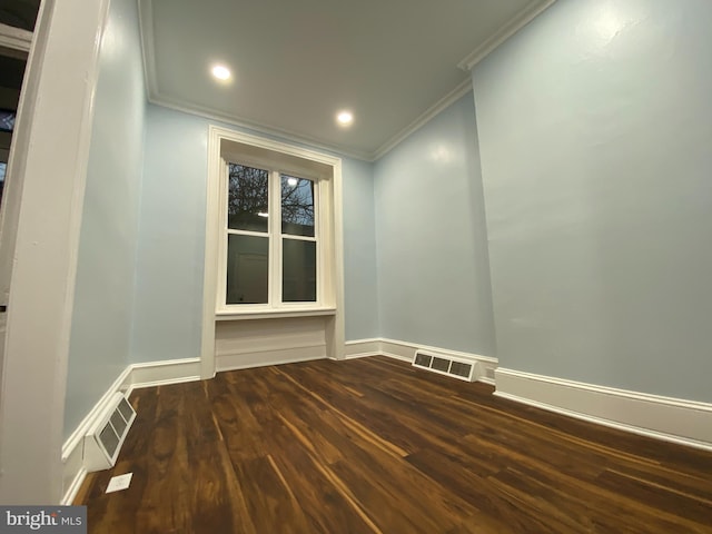 empty room featuring crown molding and dark hardwood / wood-style floors