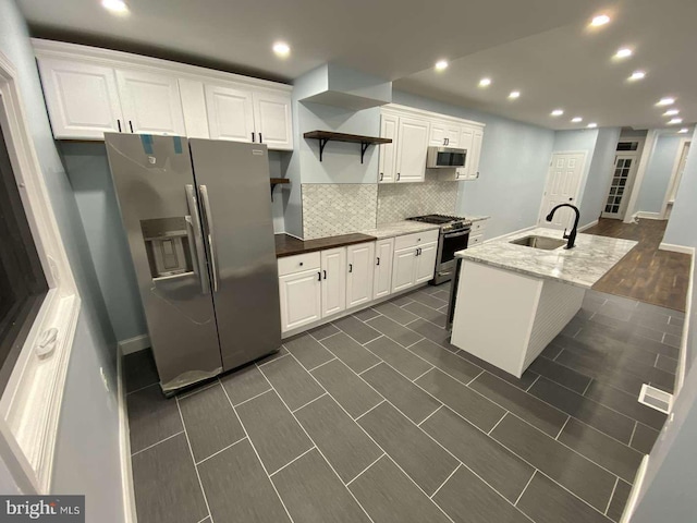 kitchen featuring an island with sink, appliances with stainless steel finishes, sink, and white cabinets