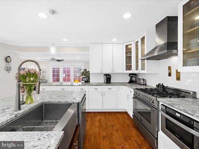 kitchen with white cabinetry, appliances with stainless steel finishes, sink, and wall chimney exhaust hood