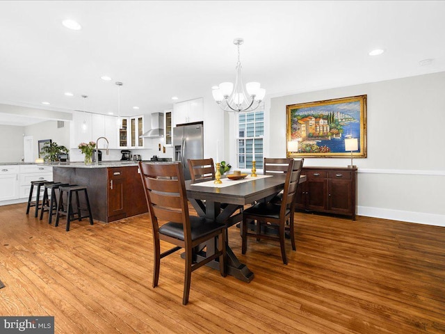 dining space featuring light hardwood / wood-style flooring and a chandelier