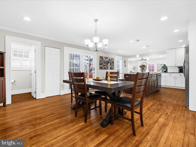 dining room featuring crown molding, dark hardwood / wood-style floors, and an inviting chandelier