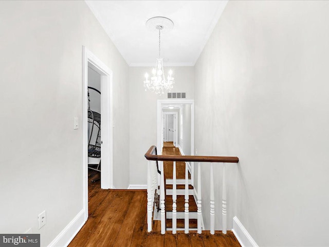 hall with dark hardwood / wood-style flooring and a notable chandelier