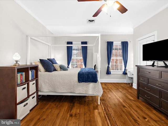 bedroom with ceiling fan, ornamental molding, and dark hardwood / wood-style flooring