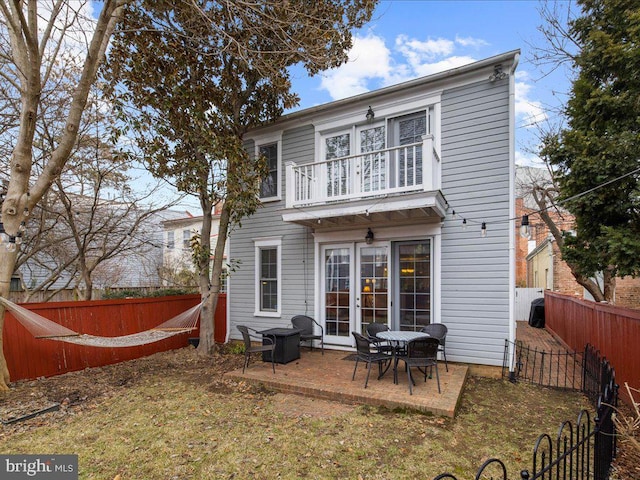 rear view of property featuring a balcony and a patio