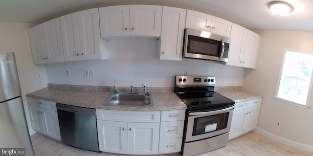 kitchen with stainless steel appliances, sink, and white cabinets