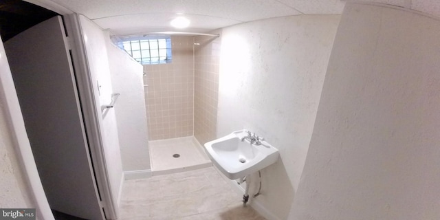 bathroom with sink and a tile shower