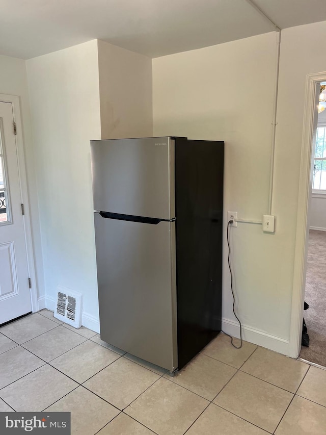 kitchen featuring light tile patterned floors and stainless steel fridge