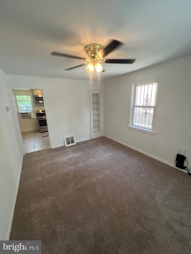 empty room featuring light colored carpet and ceiling fan