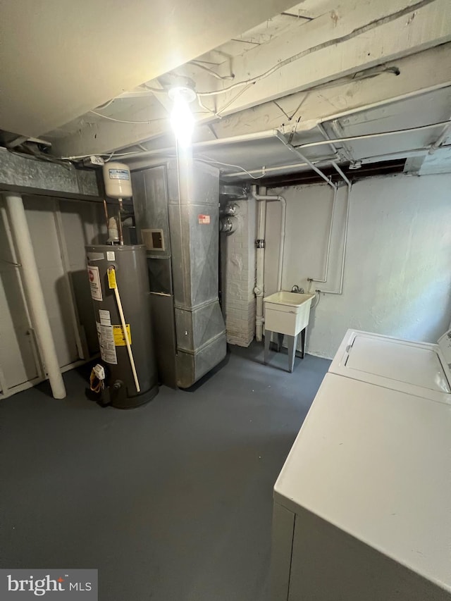 basement with washer / clothes dryer, sink, and water heater