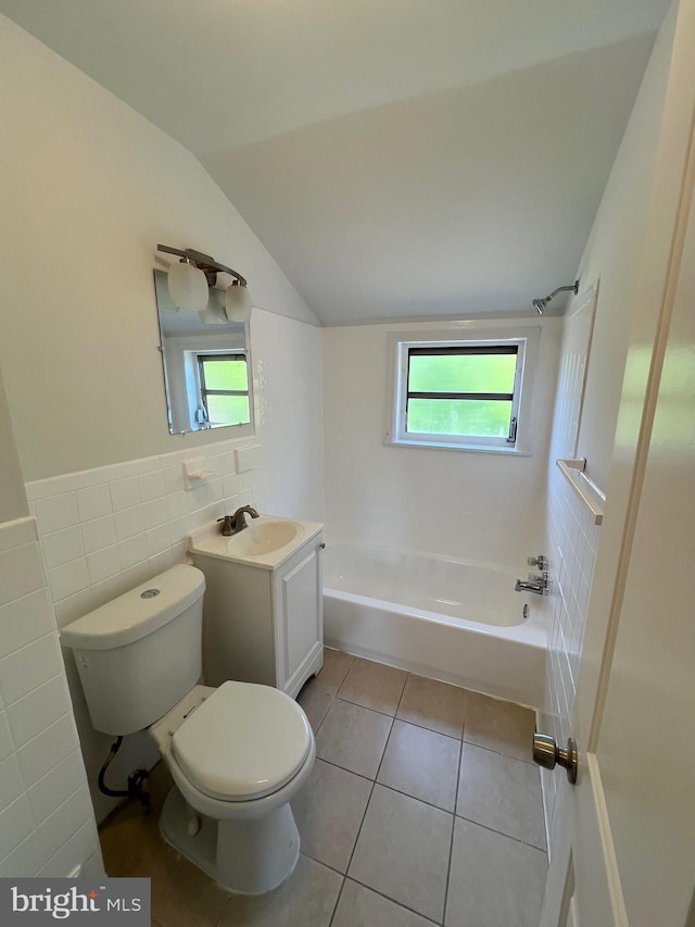 full bathroom with toilet, vaulted ceiling, tile walls, vanity, and tile patterned flooring