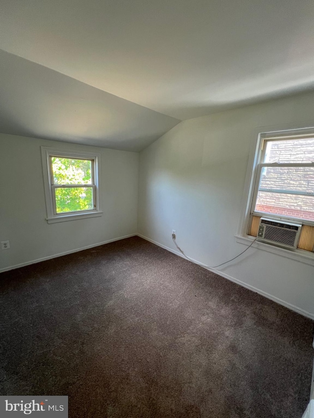 carpeted empty room with lofted ceiling and cooling unit