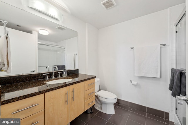 bathroom with walk in shower, tile patterned floors, vanity, and toilet