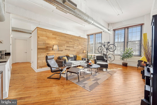 living room featuring light hardwood / wood-style flooring and wood walls