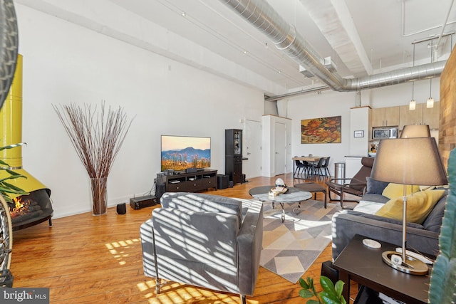 living room with a high ceiling and light hardwood / wood-style flooring