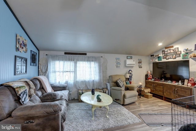 living room with lofted ceiling, a wall mounted air conditioner, and wood-type flooring