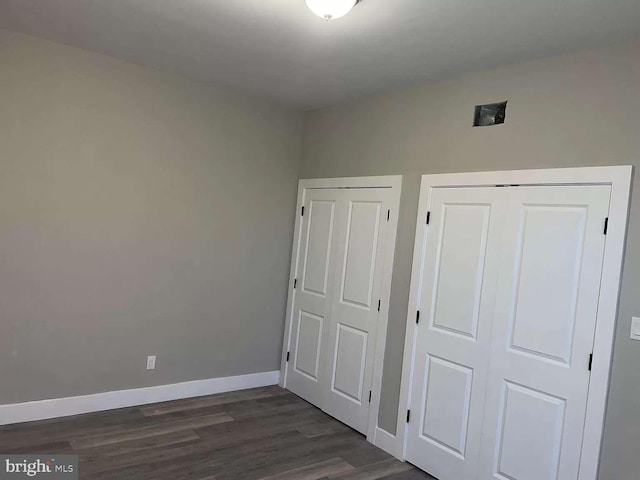 unfurnished bedroom featuring dark hardwood / wood-style floors and a closet