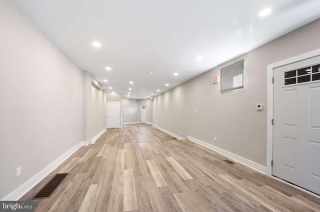 basement with light hardwood / wood-style flooring