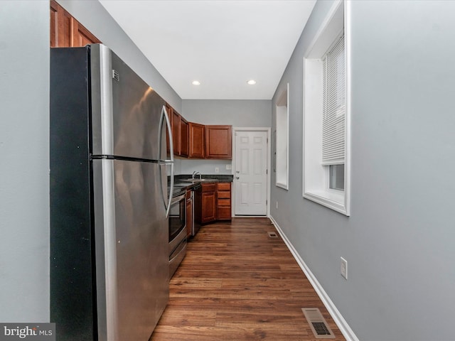 kitchen with stainless steel appliances, dark wood-type flooring, and sink