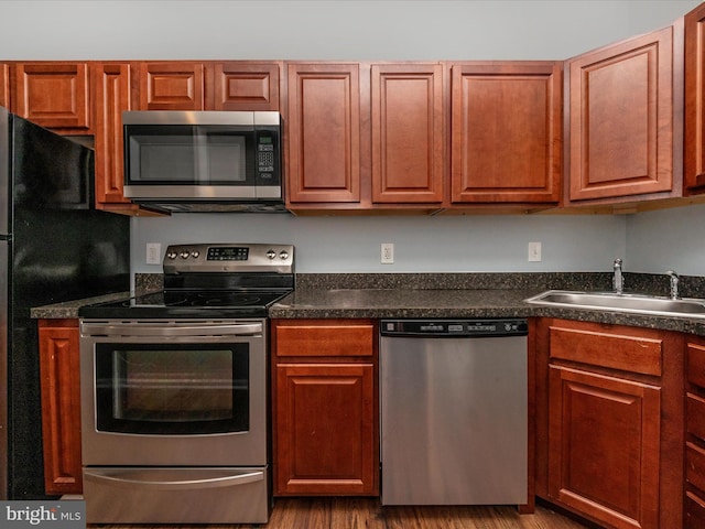 kitchen featuring stainless steel appliances, sink, and wood-type flooring