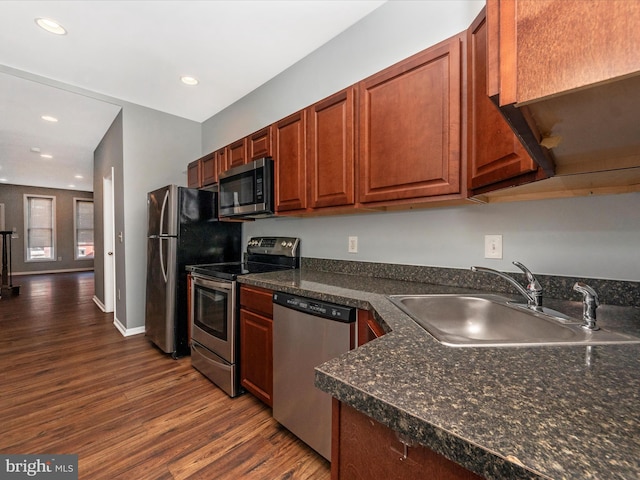 kitchen featuring appliances with stainless steel finishes, sink, and dark hardwood / wood-style flooring