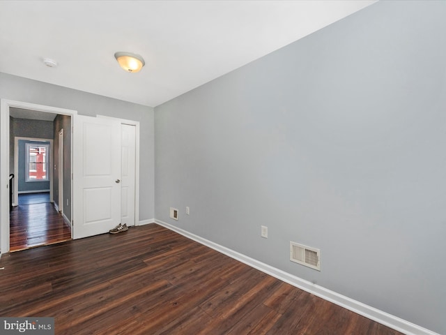 empty room with dark hardwood / wood-style flooring