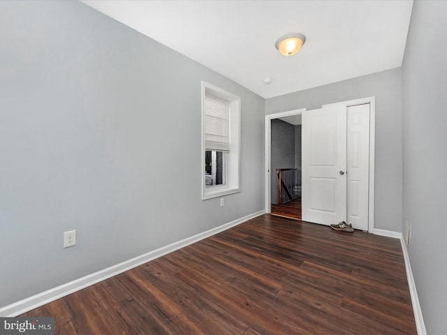 unfurnished bedroom featuring a closet and dark hardwood / wood-style floors