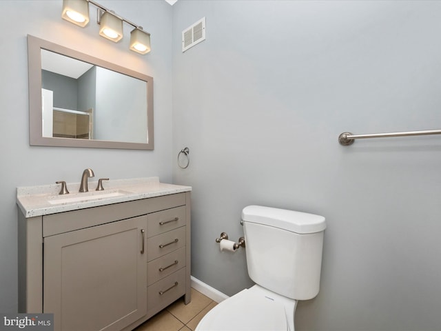 bathroom featuring tile patterned flooring, vanity, toilet, and walk in shower