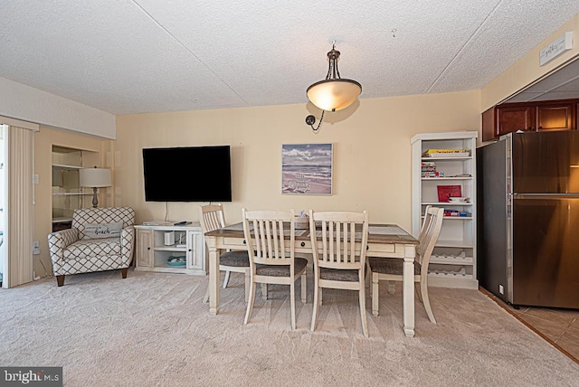 carpeted dining room featuring a textured ceiling