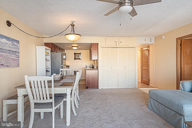 dining room with ceiling fan, light colored carpet, and a textured ceiling