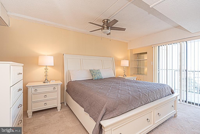 carpeted bedroom featuring ceiling fan and a textured ceiling