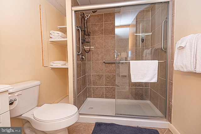 bathroom with toilet, tile patterned floors, and a shower with shower door