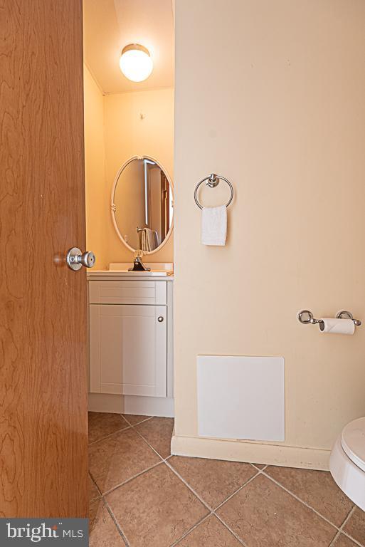 bathroom with vanity, toilet, and tile patterned flooring