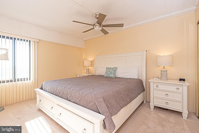 bedroom with light carpet, a textured ceiling, and ceiling fan