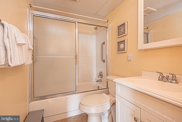 full bathroom featuring toilet, tile patterned floors, vanity, and shower / bath combination with glass door